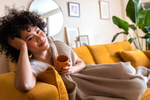 Woman enjoying CBD coffee on couch